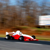 Image of the F1000 race car in motion on an outdoor track with blurred background